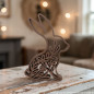 Preview: 3D-gedruckter Deko-Hase im Singleline-Design mit floralem Muster auf einem Holztisch in gemütlicher Wohnatmosphäre