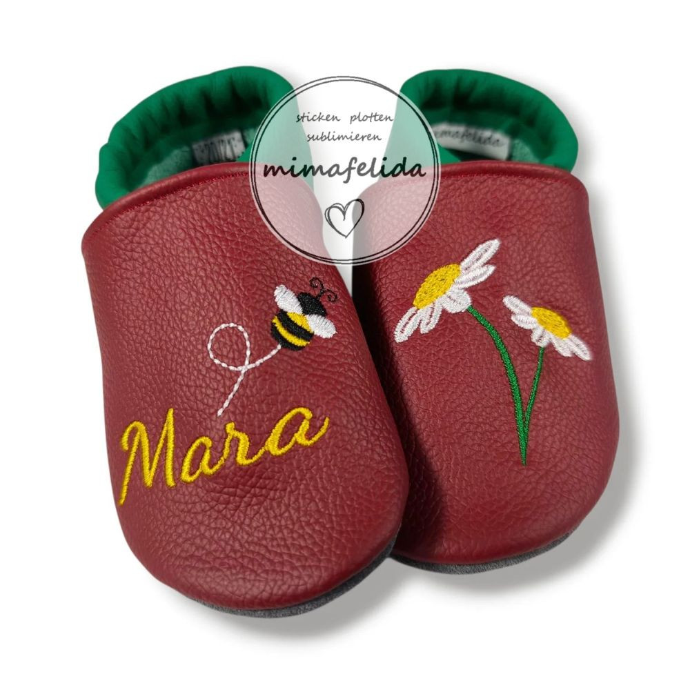 Lederpatschen mit einer Blume, Biene und Name bestickt